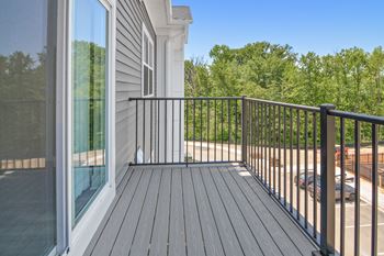 a large balcony with a sliding glass door and a view of a parking lot